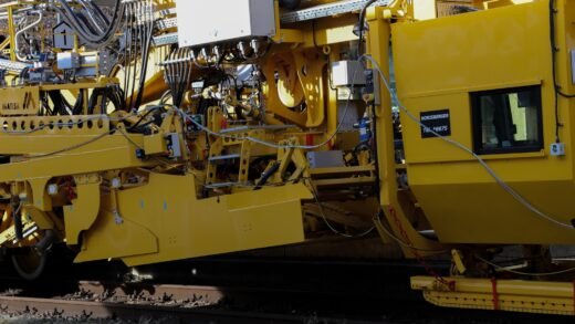 Yellow construction machinery on train tracks.